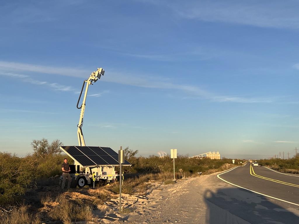 A person standing next to a solar panel

Description automatically generated